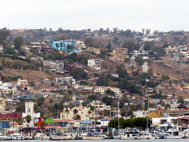 Small boats in foreground, hill and city in background.