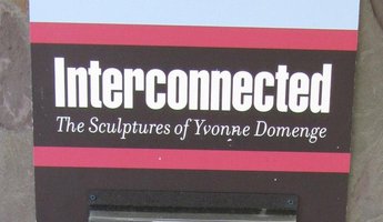 Sign reading “Interconnected - The Sculptures of Yvonne Domenge”