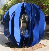 Blue plastic spherical sculpture made of irregularly shaped circular sections rotated around the vertical axis