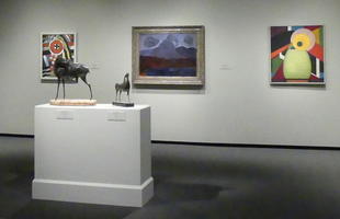 Paintings in background, sculpture in foreground.