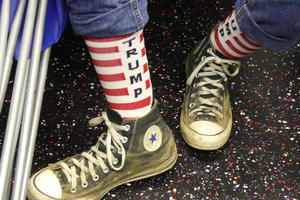 Person wearing TRUMP socks in red white and blue.