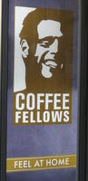 Silhouette of smiling man on sign for "Coffee Fellows - Feel at home'