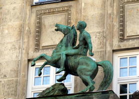 Sculpture of rider on horse with front legs in air.