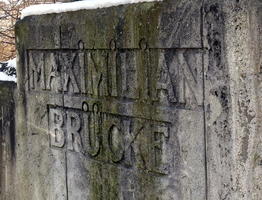 Stone on bridge with "Maximilian Brücke” (Bridge) engraved in relief