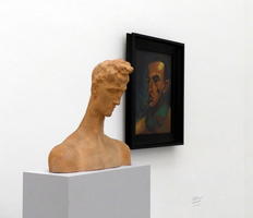 Bust of man with downcast face; painting of another man in background