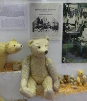 Display with seated original Steiff teddy bear