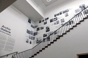 View up staircase to archive gallery showing photos of famous artists