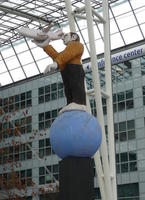 Man standing on globe, holding airpane in hand