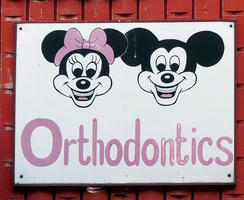 Orthodontics sign with very creepy Mickey and Minnie Mouse