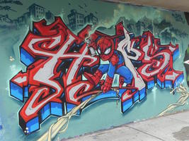 Spider-man with spray paint can swinging through graffitti