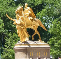 Gold statue of man on horse led by Lady Liberty at entrance to Central Park