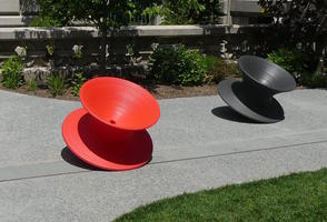 Gray and red chairs shaped like spinning top toys