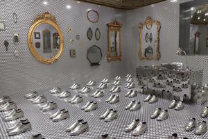 Room with many mirrors and many pairs of silver-plated dress shoes
