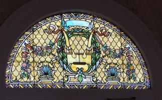 Stained glass above a door; harp is central theme
