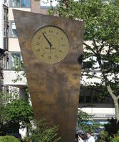 Bronze trapezoidal sculpture with large clock