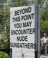 Large sign: Beyond this point you may encounter nude sunbathers