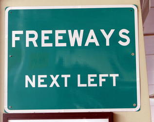 Badly kerned all-caps sign reading “FREEWAYS NEXT LEFT”—the Y and S are too far apart.