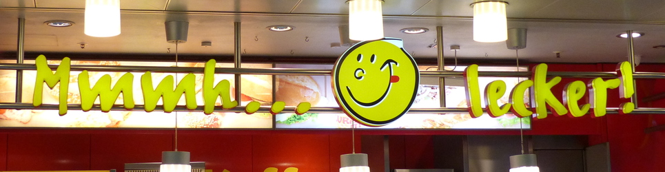 Sign with  “Mmmm... Delicious!” in German with smiley face licking its chops between the words.