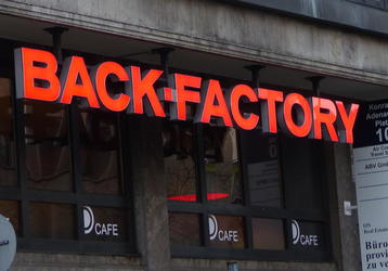 Red neon sign “BACK-FACTORY”