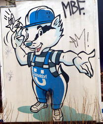 Poster of raccoon in work clothes; graffitti'ed with a bird on his hand