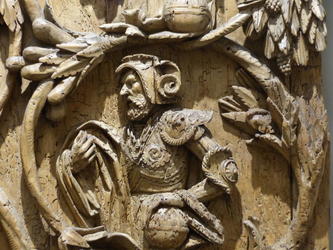 Closeup of wood carving showing man in knightly garb