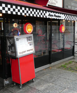 “Auto Passion” restaurant; in front is a red gasoline pump that shows the restaurant menu.