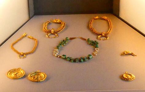 Necklaces; gold, and one with green stones