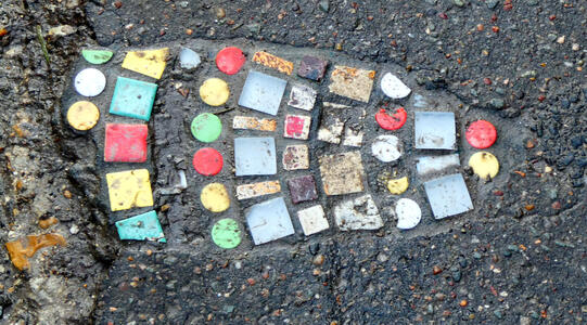 multiple colored circular and square stones inlaid into sidewalk