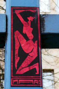 Red sticker showing back 3/4 profile of nude woman in a pose with arm uplifted and one leg’s toe pointed
