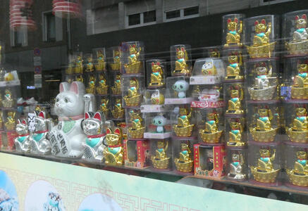 Large number of Japanese “good luck” cats in window of an Asian grocery