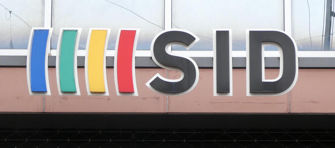 Logo with blue, green, yellow, red vertical bars before letters SID