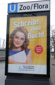 Advert for Germany’s largest school for writers; shows woman in glasses: Write! Your! Book!