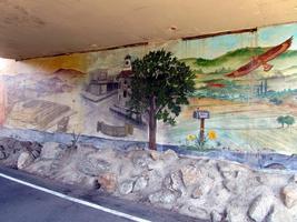 Mural showing “Gilroy through the years” painted on wall of an underpass.