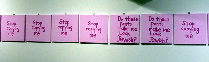Multiple non-identical posters: “Stop copying me” interspersed with “Do these pants make me look Jewish?”