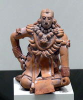 Terra cotta seated man wearing large necklace with animal teeth