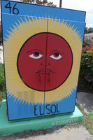 Red sun with face and yellow rays; subtitled “El Sol”