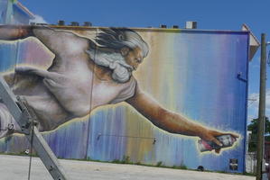 Wall painting patterned after Michelangelo’s creation of Adam showing the Lord with a spray paint can
