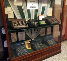 Display case with old electro-mechanical calculators; labeled “Museum of Antiquities”