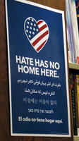 Heart filled with American flag design: Hate has no home here. (repeated in arabic, farsi, korean, hebrew, and spanish)
