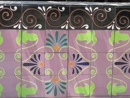 Tiles in vine and flower motif on purple background