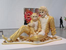 Sculpture of Michael Jackson holding a chimp; both dressed in gold lame