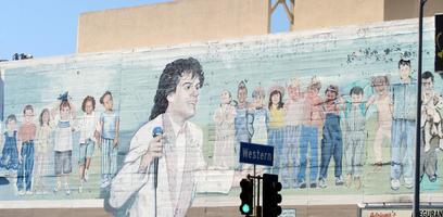 Mural of badly-drawn Michael Jackson in foreground with children in background.