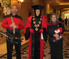 Man and woman in Star Fleet uniforms on either side of Q (dressed as “judge”)