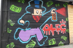 Painted garage door; monopoly man in mask with spray paint can