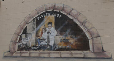 Mural of barber giving a child a haircut