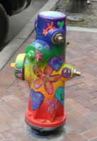 Hydrant painted with flowers and words “Peace,” “Paz,” and “Love.”