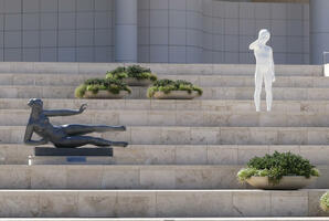 Stairway at entrace to getty; black sculpture of reclining woman at left, white sculpture of small child at right