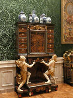 Wood cabinet with ceramic vases on top; cabinet supported by cherubim