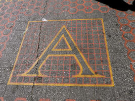 Capital letter A inlaid into street crossing