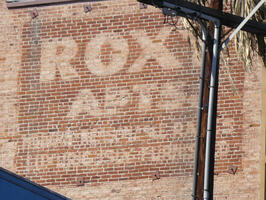 Brick building with faded advert for Roxy Apartments
